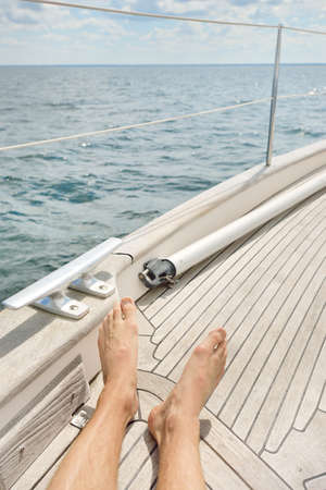 Man chilling in a sailboat, wooden teak deck, open sea. Old expensive classic yacht. Freedom,...