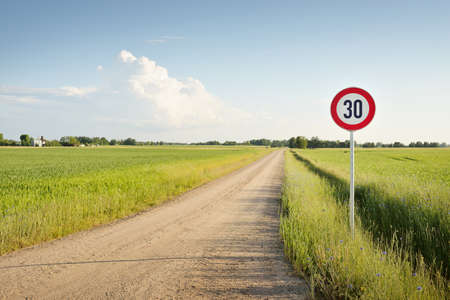 Driving a car through the green country fields and forest on a sunny day. Clear blue sky. Idyllic...