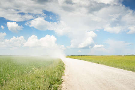Driving a car through the green country fields and forest on a sunny day. Clear blue sky. Idyllic...