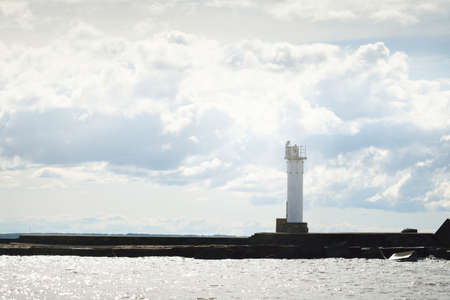Epic cloudscape. Lighthouse against dramatic sky with ornamental cumulus clouds before the rain. Fickle weather. Baltic sea. Texture, background, wallpaper, graphic resources, design, copy spaceの写真素材