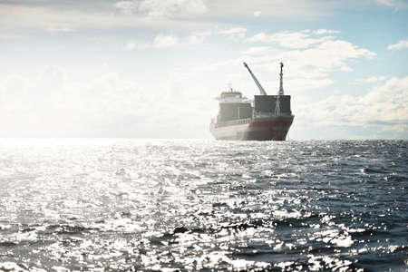 Large modern general cargo crane ship sailing in an open sea. Freight transportation, nautical...