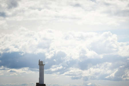 Epic cloudscape. Lighthouse against dramatic sky with ornamental cumulus clouds before the rain. Fickle weather. Baltic sea. Texture, background, wallpaper, graphic resources, design, copy spaceの写真素材