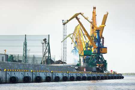 Modern coal terminal in Riga, Latvia. Cranes close-up. Baltic sea. Freight transportation, logistics, global communications, economy, business, industry, supply, special equipment. Urban landscapeの写真素材