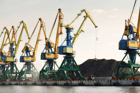 Modern coal terminal in Riga, Latvia. Cranes close-up. Baltic sea. Freight transportation, logistics, global communications, economy, business, industry, supply, special equipment. Urban landscapeの写真素材