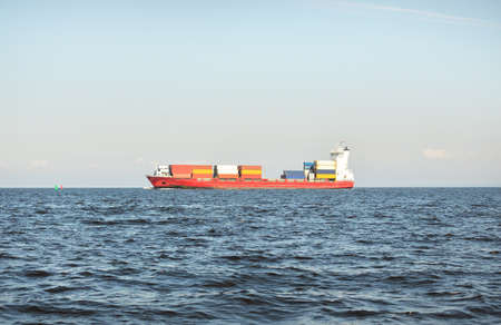 Large cargo container ship (141 meters length) sailing in the Baltic sea. Freight transportation, logistics, global communications, economy, industry, supply, environmentの写真素材