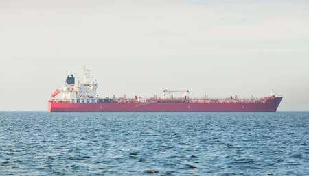 Large red cargo ship (oil chemical tanker, 184 meters length) sailing in the Baltic sea. Freight transportation, logistics, global communications, economy, industry, supply, environmentの写真素材