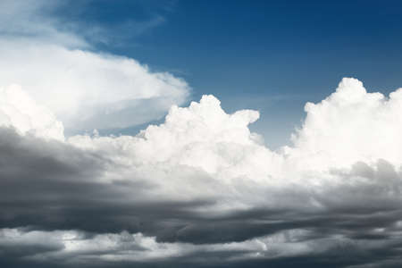 Epic storm cloudscape. White ornamental sunset cumulus clouds. Soft sunlight, sun rays. Clear blue sky. Natural pattern, texture, background, wallpaper, 3D, graphic resources, design, copy spaceの写真素材