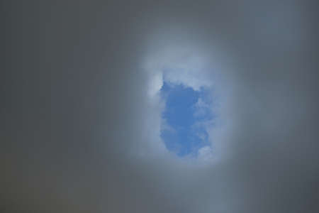 Epic storm cloudscape. White ornamental sunset cumulus clouds. Soft sunlight, sun rays. Clear blue sky. Natural pattern, texture, background, wallpaper, 3D, graphic resources, design, copy spaceの写真素材