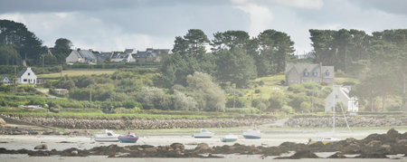 Shallow water of Lilia bay and the village near the Ãle Vierge lighthouse on a sunny day. Plouguerneau, FinistÃ¨re, Brittany, France. Travel destinations, national landmark, recreation themeの写真素材