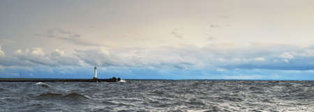 Panoramic view to the North sea from a sailing boat at sunset. Lighthouse. Dramatic stormy sky, sun...
