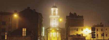 Empty illuminated street near the Evangelical Lutheran Church of Jesus in a fog at night....