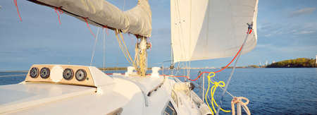 White yacht sailing in the Baltic sea after the rain at sunset. Riga, Latvia. Close-up view from the...