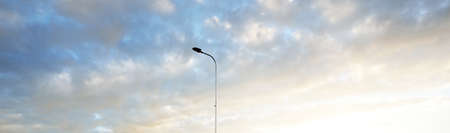 Street lights (lantern) against dramatic sunset sky. Glowing pink and golden clouds after the storm. Concept art, meteorology, heaven, hope, peace. Graphic resources, picturesque panoramic sceneryの写真素材