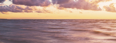 Epic colorful glowing pink sunset clouds above the sea after a thunderstorm. Dramatic sky. Waves and...