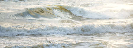 Baltic sea after a thunderstorm at sunset. Ventspils, Latvia. Waves and water splashes. Epic seascape. Cyclone, gale, storm, fickle weather, meteorology. Natural pattern, background, textureの写真素材