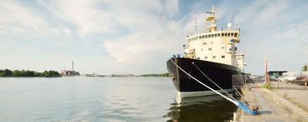 Icebreaker moored to a pier on a summer day. Helsinki, Finland. Concept landscape. Industry, logistics, global communications, freight transportation, nautical vessel, environmental damageの写真素材