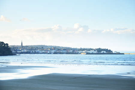 Panoramic cityscape, a view from the coast of bay of Douarnenez. Blue sky with colorful evening clouds. Reflections on the water. Brittany, Franceの写真素材