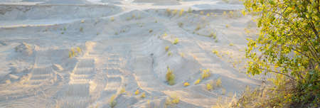 Panoramic view of the quarry on a clear day. Sandy peaks and sand texture close-up. Environmental damage, ecological issues, business, construction industry, special equipment, destruction, technologyの写真素材
