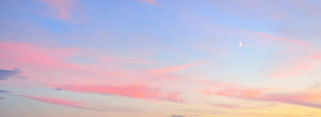 Clear blue sky, glowing pink and golden clouds after storm at sunset. Dramatic cloudscape. Moon,...