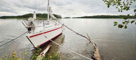 Yacht anchored to the rocky shore. 32 feet swedish built cruising sailboat. RidÃ¶n island, lake MÃ¤laren, Sweden. Nature, summer vacations, recreation, cruise, sport, transportation, ecotourismの写真素材