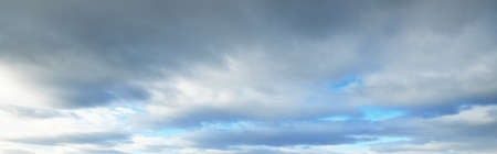 Coudscape. White ornamental clouds. Soft sunlight, sunbeams. Clear blue sky. Natural pattern, texture, background, wallpaper, graphic resources, design, copy space. Symbol of peaceの写真素材