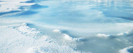 Ice pressure ridge on a frozen sea shore on a clear day, texture close-up. Picturesque winter...