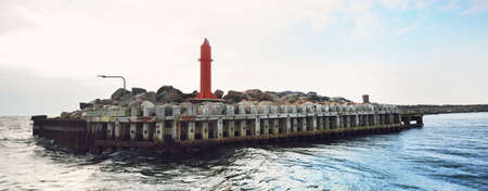 Port entrance mole close-up. A view from the sailing boat. Waves and water splashes. Kattegat, Anholt island, Denmark. Travel destinations, navigation, transportation themeの写真素材