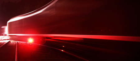 Large cargo train with goods leaving the terminal at night, wagons (containers) close-up. Concept...