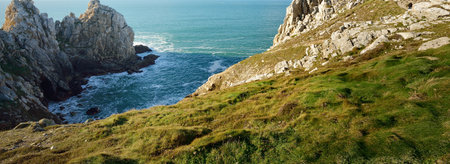 Aerial view of the rocky shore of Pointe de Pen-Hir, cliffs close-up. Azure water, stormy waves. Dramatic cloudscape. Crozon peninsula, Brittany, Franceの写真素材