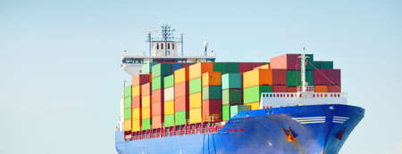 Large cargo container ship sailing from Europoort (Rotterdam, Netherlands) in an open sea on a clear day, green navigational buoy close-up. Global communications, logistics, industry themeの写真素材