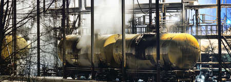 Cargo train wagons loading with fossil fuel at the terminal at night. Riga, Latvia. Dark industrial...