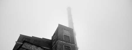An old red brick building with a pipe. Factory in a fog. Concept urban scene, landscape. Economy,...