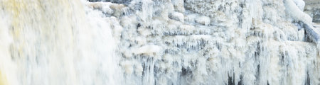 Frozen Keila waterfall, icicles and water splashes close-up. Winter in Estonia. Abstract natural...