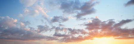Clear blue sky with glowing pink and golden clouds after the storm. Dramatic sunset cloudscape....