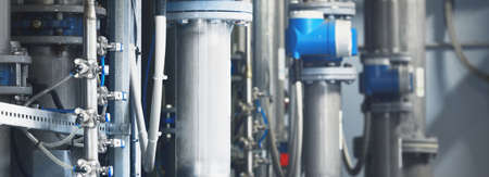 Large industrial water treatment and boiler room. Shiny steel metal pipes, pumps, valves. Industry,...