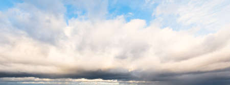 Ornamental clouds. Dramatic sky. Epic storm cloudscape. Soft sunlight. Panoramic image, texture, background, graphic resources, design, copy space. Meteorology, heaven, hope, peace conceptの写真素材