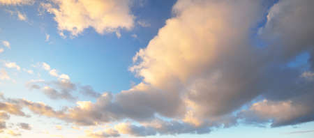 Clear blue sky with glowing pink and golden clouds after the storm. Dramatic sunset cloudscape....