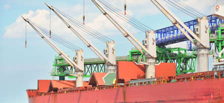 Large cargo ship loading in port terminal. Panoramic view. Freight transportation, nautical vessel,...