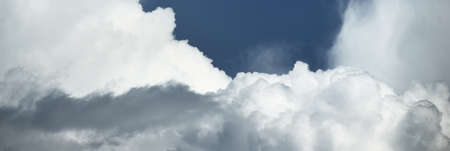 Epic cloudscape. White ornamental cumulus clouds before the rain. Fickle weather, sun rays. Baltic sea. Natural pattern, texture, background, wallpaper, 3D, graphic resources, design, copy spaceの写真素材