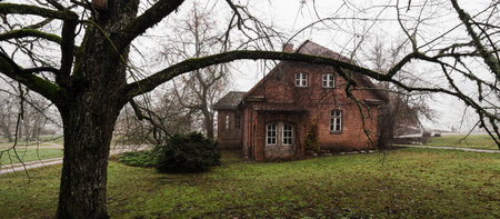 Traditional red brick house in a fog. Rural area. Atmospheric autumn country landscape. Panoramic...