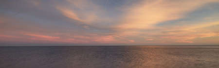Baltic sea under the colorful sunset sky. Stunning seascape. Golden sunset light through the pink...