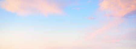 Clear blue sky. glowing pink and golden cirrus and cumulus clouds after storm, soft sunlight. Dramatic sunset cloudscape. Meteorology, heaven, peace, graphic resources, picturesque panoramic sceneryの写真素材