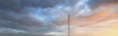 Clear blue sky. glowing pink and golden cirrus and cumulus clouds after storm, soft sunlight. Dramatic sunset cloudscape. Meteorology, heaven, peace, graphic resources, picturesque panoramic sceneryの写真素材