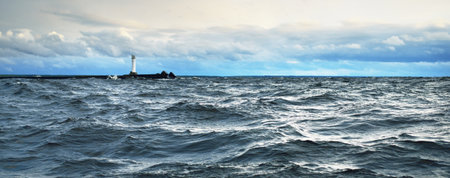 A view to the North sea from a sailing boat at sunset. Dramatic stormy sky, sun rays through the...