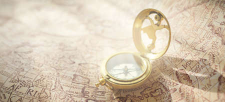 Retro styled golden compass (sundial) and old white nautical chart. Vintage still life. Sailing...