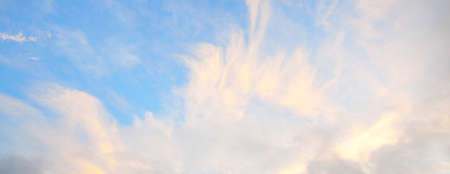 Ornamental clouds. Dramatic sky. Cloudscape. Soft sunlight. Panoramic image, texture, background, graphic resources, design, copy space. Meteorology, weather, climate, heaven, hope, peace conceptsの写真素材