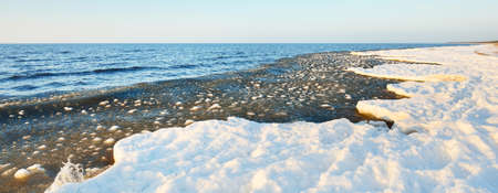 Frozen Baltic sea shore on a clear day, snow texture close-up. Blue sky. Picturesque winter scenery....