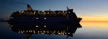 Passenger ship (cruise liner) sailing in the Baltic sea at sunset, panoramic view. Midnight sun....
