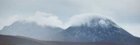Mountains peaks under the dark storm sky. Dramatic clouds. Jura island, Inner Hebrides, Scotland,...