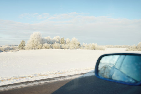 Country road through the snow-covered fields, rural area. View from car. Snow drifts. Europe....